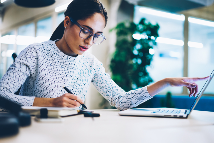 Pensive business woman noting idea for startup planning from web